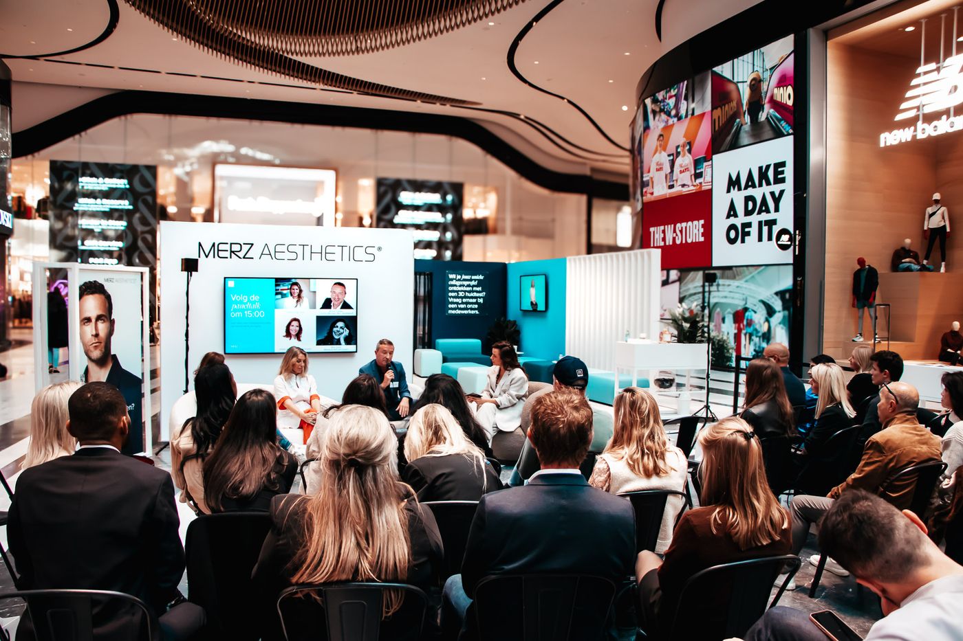 Merkevent met bezoekers bij een stand met presentatiescherm
